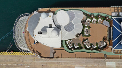 Naklejka premium Aerial drone top down photo of huge cruise liner anchored in Mediterranean port top deck facilities