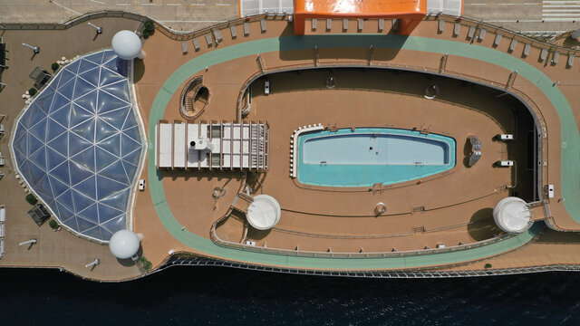 Aerial drone top down photo of huge cruise liner anchored in Mediterranean port top deck facilities