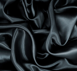 Smooth elegant black silk or satin texture as abstract background. Luxurious background design