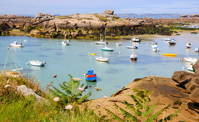Brittany, France. Boats and people at Pink Granite Coast during low tide. The coast between...