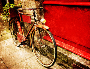 Rusty vintage red bicycle leaning with on red wooden board (useful for entering a text advertisement, menu etc) and carrying plants in wooden box as decoration. Retro aged photo with scratches.
