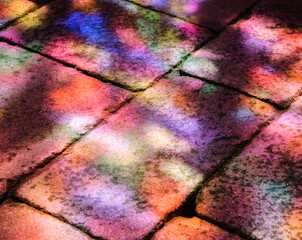 Colorful light spots on the stone brick floor. Sunlight filtered through the stained glass window....