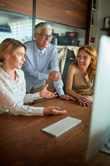 Fototapeta premium Group of female office staff working together on some task at the workplace. Business, office, job