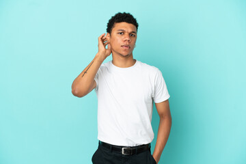 Young African American man isolated on blue background having doubts