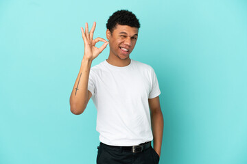 Young African American man isolated on blue background showing ok sign with fingers