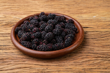 Blackberries in a plate over wooden table