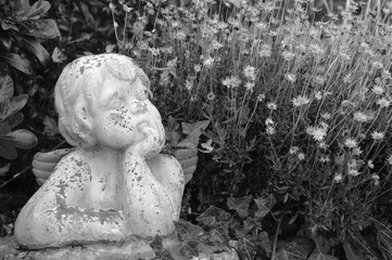 Mourning angel statue in cemetery. Black white historic photo