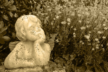 Mourning angel statue in cemetery. Sepia historic photo
