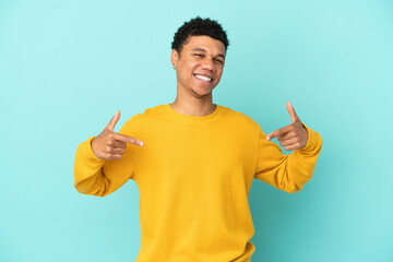 Young African American man isolated on blue background proud and self-satisfied - obrazy, fototapety, plakaty