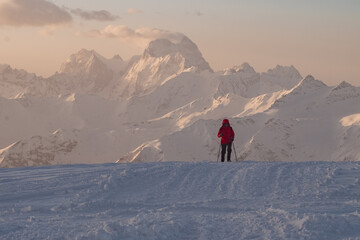 Fototapeta na wymiar silhouette of alpinist climber man in red jacket in mountains. Elbrus Mountain