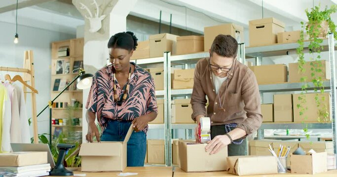 Caucasian young male and African American female clothing store workers together working in shop warehouse packing ordered clothes in parcels. Fashion business. Preparing box for shipping Work concept