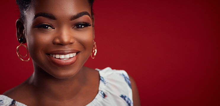 portrait of beautiful smiling african american woman on red background