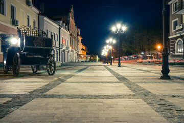 Beautiful road at night in the old part of the city.Night boulevard lined with tiles with street lamps in the historical part of the city of Kamianets-Podilskyi. Ukraine.