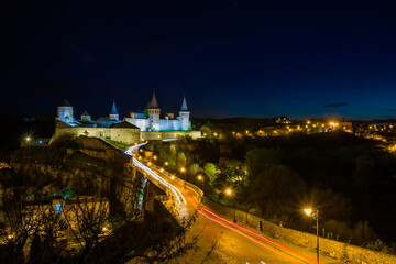 Fototapeta na wymiar View on the Kamianets-Podilskyi castle in the night. Beautiful stone castle on the hill at night. Long exposure. Illumination of the castle. Ukraine