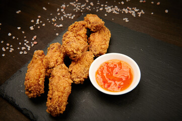 chicken wings fast food on a slate plate with sauce