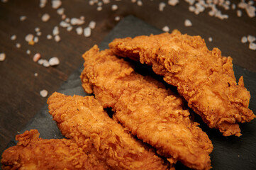 closeup of fast food chicken strips on a plate