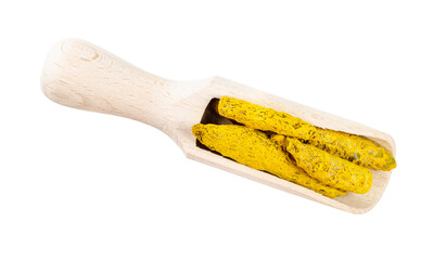 dried roots of Turmeric in wooden scoop cutout
