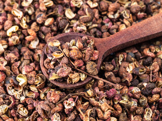 spoon on pile of dried pink sichuan pepper closeup