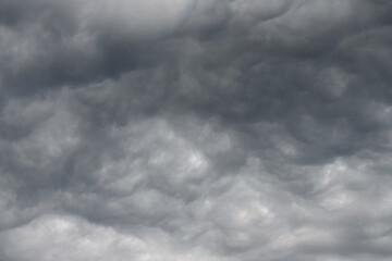A moody gray sky with bubbling clouds hanging down as dark colored cotton candy