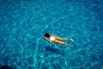 young woman dives through crystal clear waters in greece