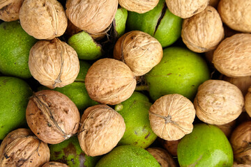 Walnuts fruit food background. Heap of walnuts in shell with green pericarp, top view