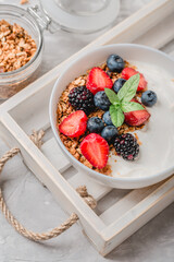 Healthy breakfast with granola, yogurt, fruits, berries on white background.