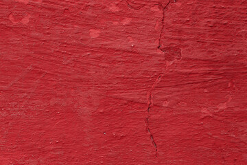 Texture of the red stucco wall with scratches, cracks, dust, crevices, roughness. Can be used as a poster or background for design.