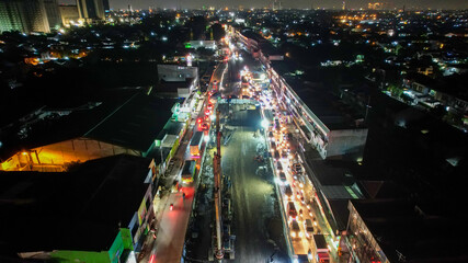Fototapeta na wymiar Traffic jam on the polluted streets of Bekasi at night. The traffic congestion is limited in few areas, selective focus on the road. Bekasi, Indonesia, May 8, 2021