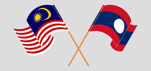 Crossed and waving flags of Malaysia and Laos