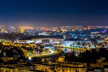 Night view of the city of Cluj-Napoca and its football stadium - obrazy, fototapety, plakaty