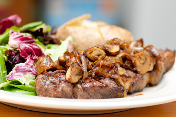 new york strip steak with salad and baked potato - Powered by Adobe