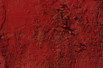 Red textured concrete  wall with natural defects. Scratches, cracks, crevices, chips, dust, roughness. 