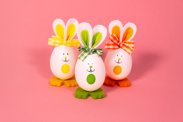 Obraz premium Ideas for holiday decoration. Easter eggs looking like a rabbit. With a painted face. On a light pink background. Copy space. Isolated