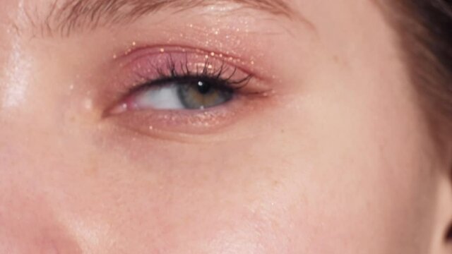 Natural beauty. Female cosmetic. Nude makeup. Perfect skin. Unrecognizable woman eye with pastel eyeshadow looking at camera selective blur.