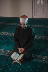 Muslim man praying in mosque and reading Quran