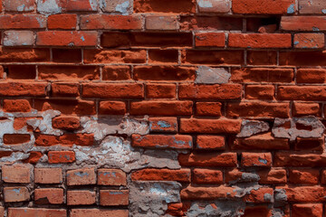 Old shabby wall with elements of destroyed bricks. Can be used as background for design or poster. Red brick background.