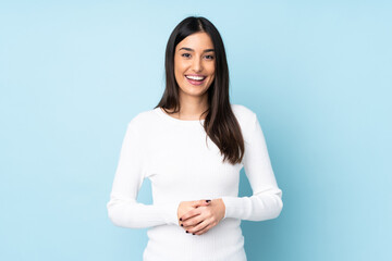 Young caucasian woman isolated on blue background laughing