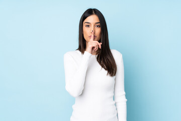 Young caucasian woman isolated on blue background showing a sign of silence gesture putting finger...
