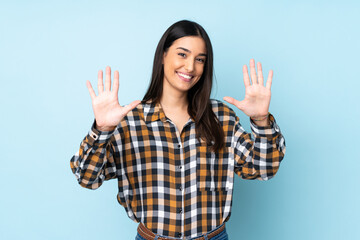 Young caucasian woman isolated on blue background counting ten with fingers