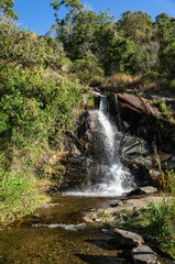 Crystal clear water flowing down between the rock formations of Mato Limpo waterfall surrounded by green vegetation. Cascade located by Salvador Pacetti road in Cunha, Sao Paulo - Brazil.