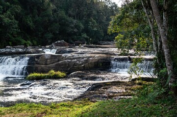 Paraibuna river crystal clear waters flowing around rock formations at the beginning of the hiking trail of the river located in the middle of Serra do Mar forest in Cunha, Sao Paulo - Brazil.