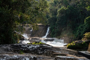 Obraz premium Distant shot of strong clear water current of Barracao waterfall. This is one of many cascades of Paraibuna river that runs in the middle of Sea Ridge dense jungle in Cunha, Sao Paulo - Brazil.