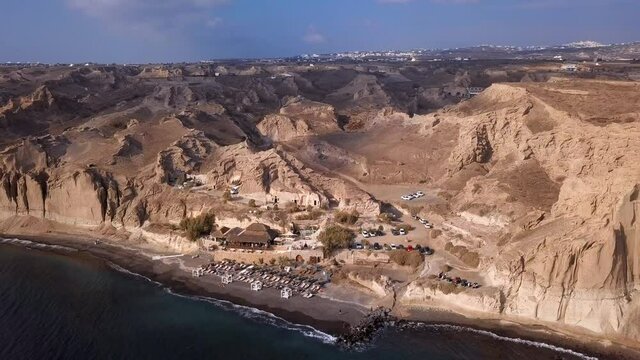 Aerial Panning Shot Of Famous Paralia Vlichada Beach Against Sky, Drone Flying Over Sea On Sunny Day - Santorini, Greece