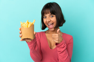 Young brunette woman holding fried chips over isolated blue background