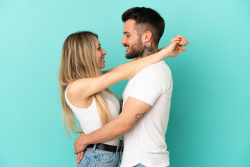 Young couple over isolated blue background hugging