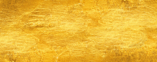 Shiny gold background made of rough textured gold leaf.