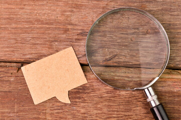 Top view of magnifying glass and bubble speech note with copy space