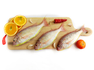 Fresh Pink Perch fish with ingredients like lemon,curry leaves,chilli,selective focus.white...