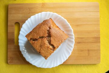 A piece of homemade marble cake on a wooden cutting board, close-up.