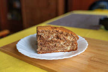 A piece of homemade marble cake on a wooden cutting board, close-up.